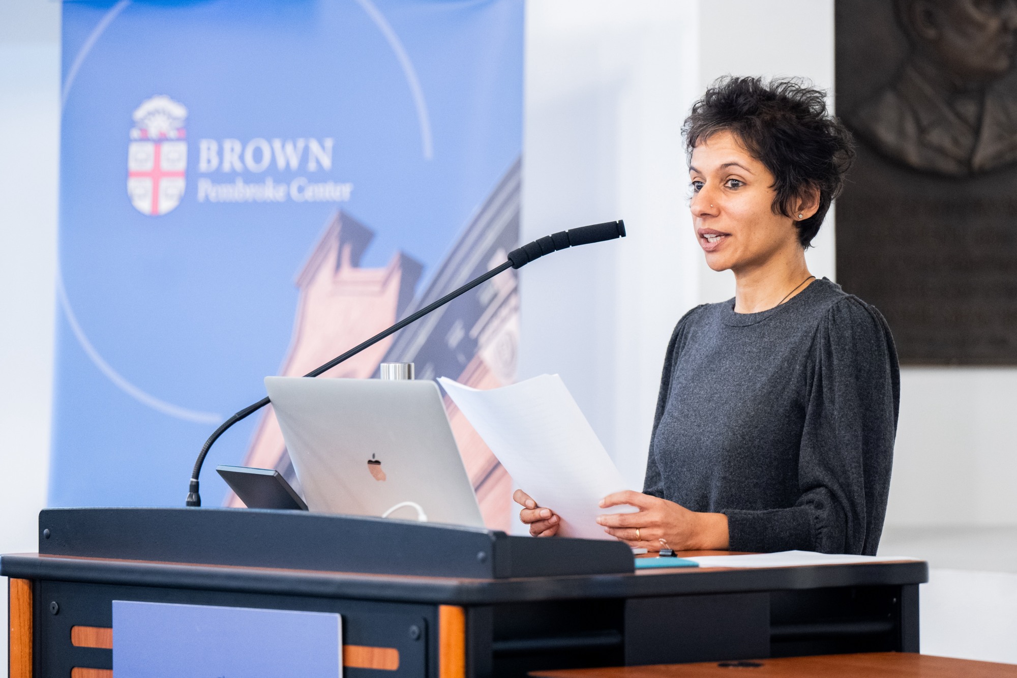 Thangam Ravindranathan speaks at a lectern.