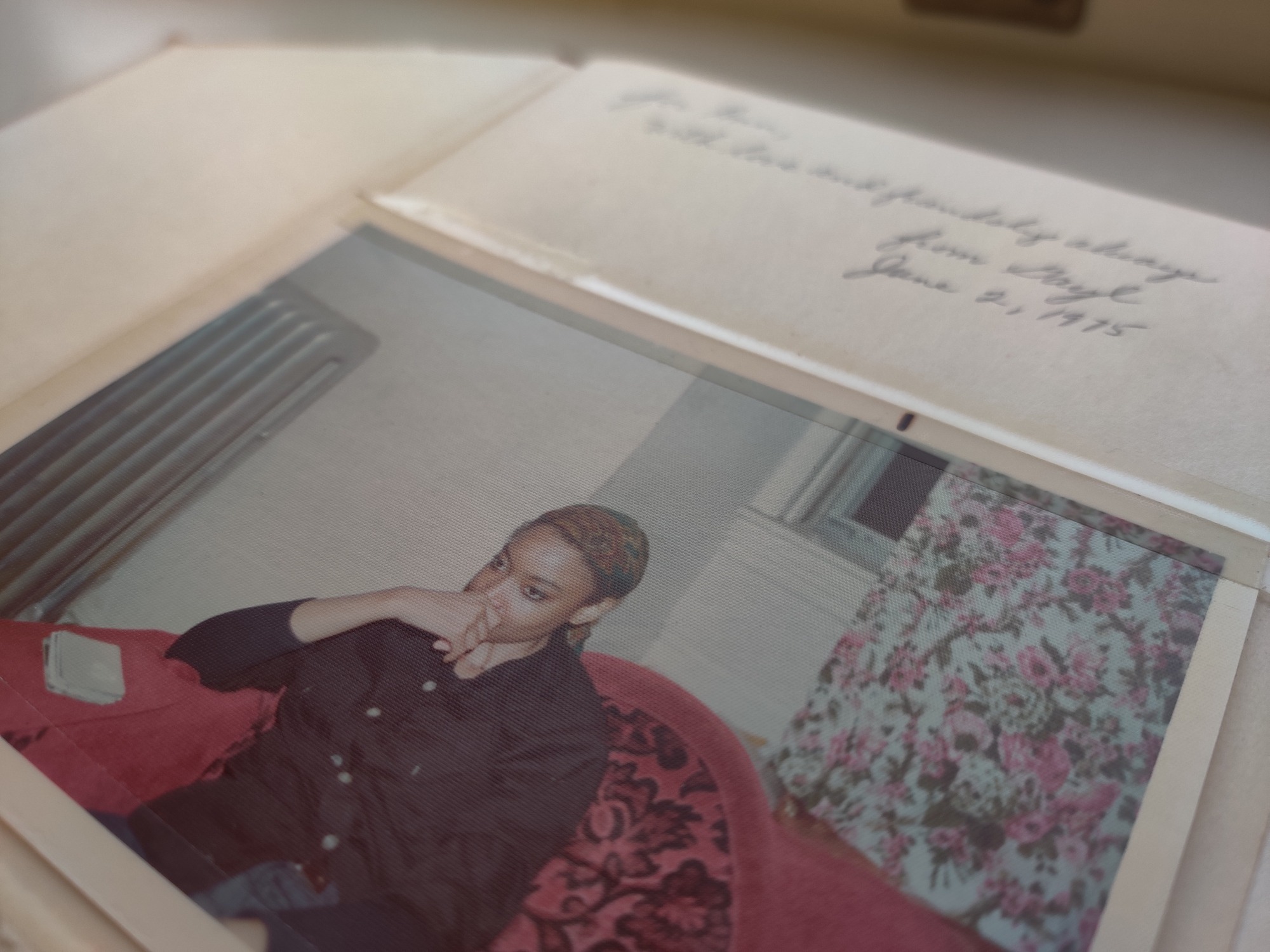 Scrapbook with handwriting at the top and a photograph below.