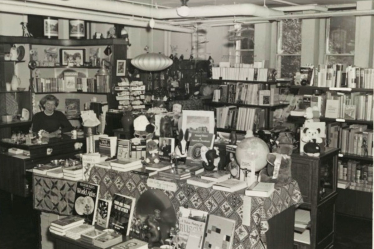 A woman sits at a desk in the Pembroke Hall basement bookstore. 