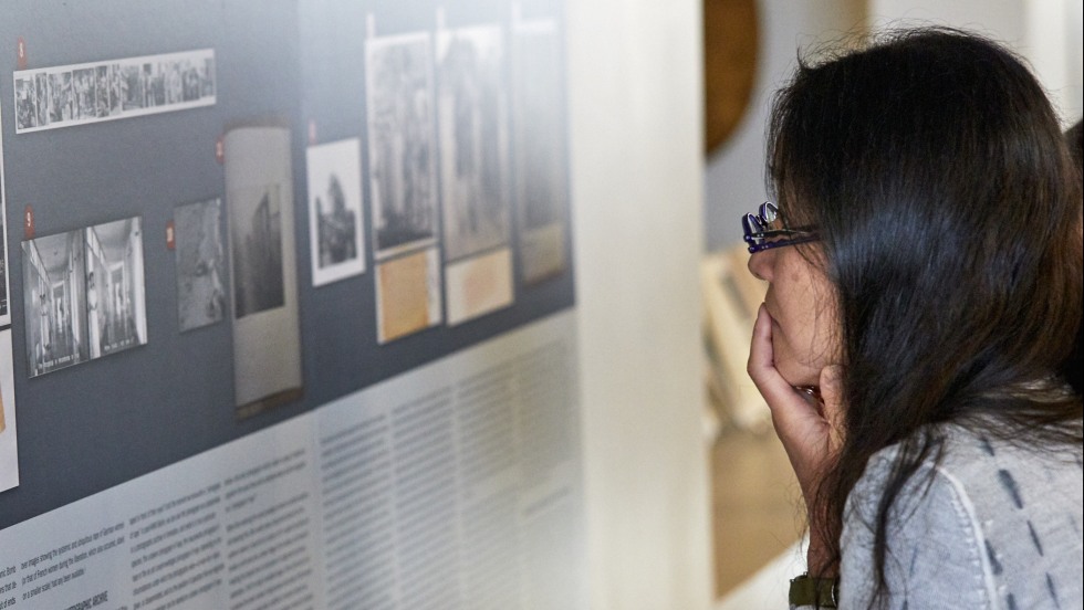 Woman looks at National History of Rape exhibition