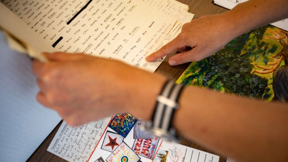 Image shows a pair of hands holding papers from the Abu-Jamal collection.